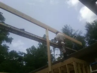 Carpenter setting a ridge beam over a new addition frame — Ice Dam Removal by Roofing Brothers in Park Ridge